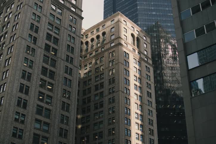 A slow zoom reveals a mix of classic and modern skyscrapers towering in a dense urban cityscape