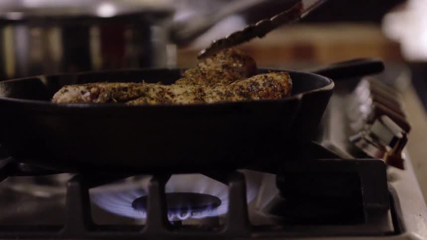 A person is cooking meat on a pan
