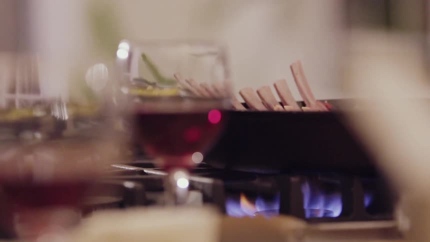 Meat is being cooked on a pan in a kitchen
