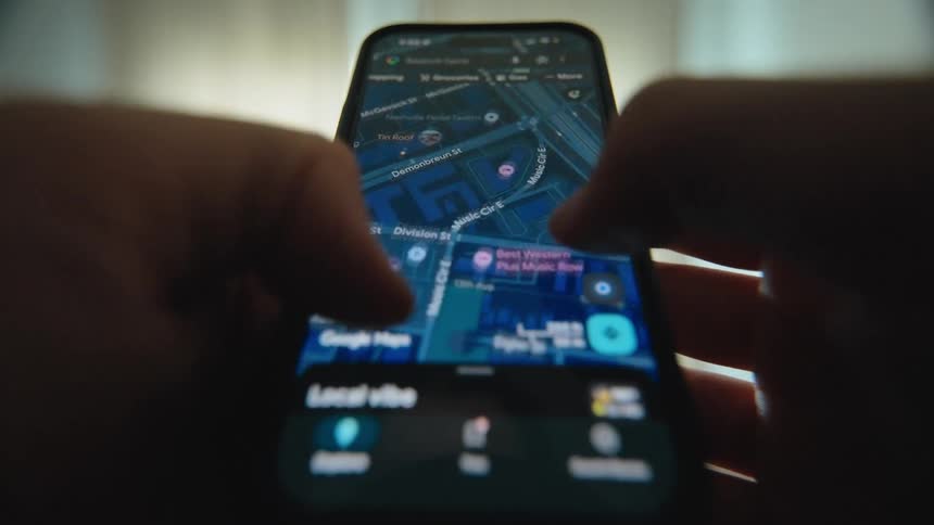 A person uses a maps application on their smartphone to navigate a city and find directions