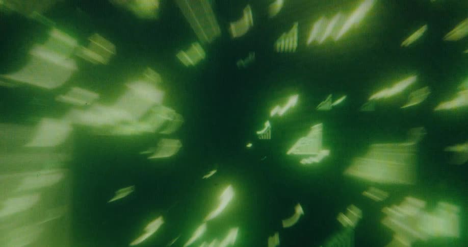 A seamless loop of glowing green financial data icons flying forward in a digital vortex