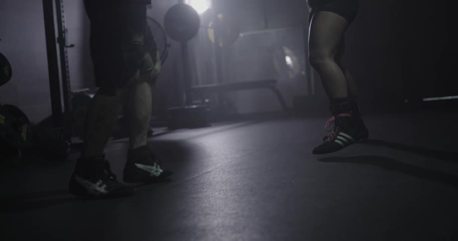 Two fighters are training in a gym