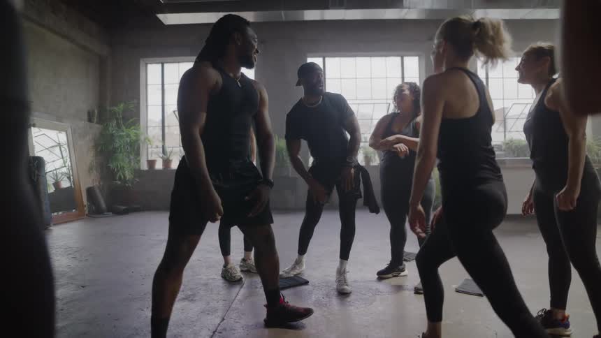 Slow motion shot of a diverse group of friends warming up and having fun in a group fitness class