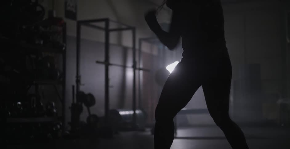 A woman is jumping back and forth shadowboxing