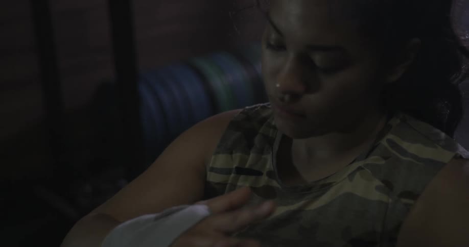 A female fighter is taping up her wrist