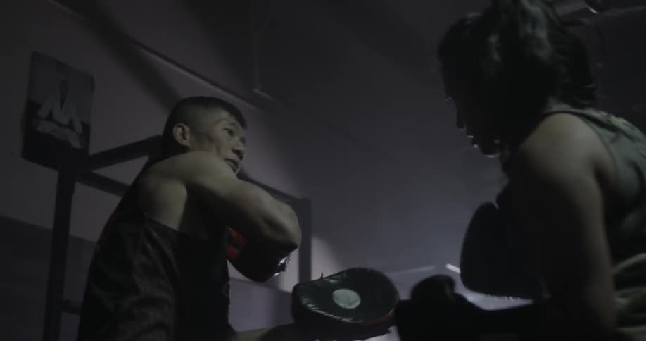 A woman boxer trains with her coach