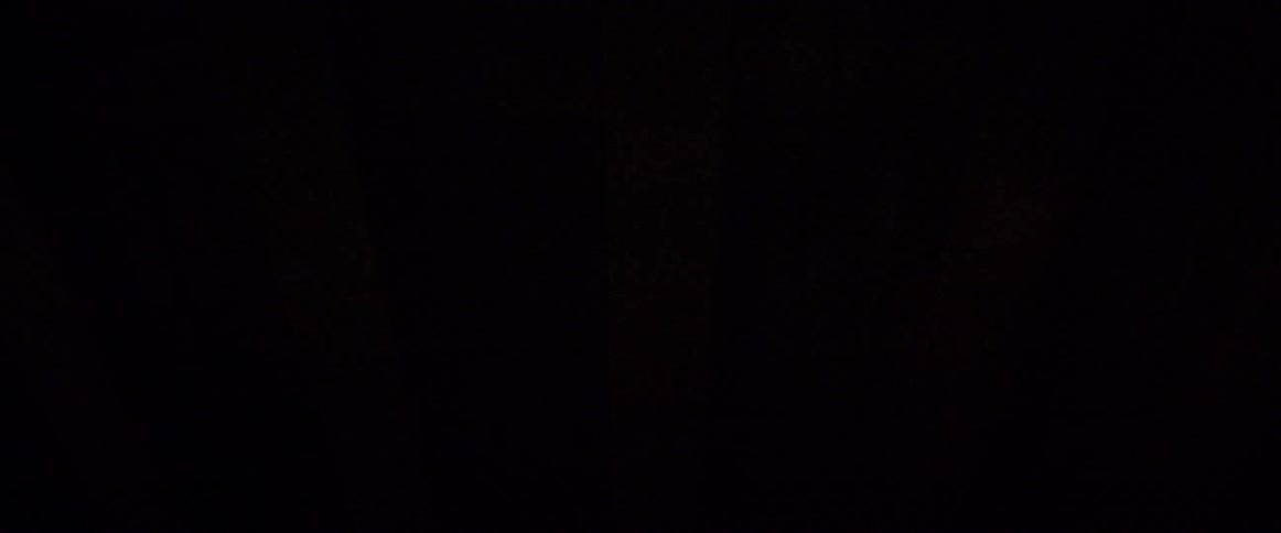 Lights shine overhead in a dark tunnel