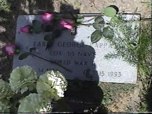 Flowers rest on the gravestone of a World War II U.S. Navy veteran in a cemetery