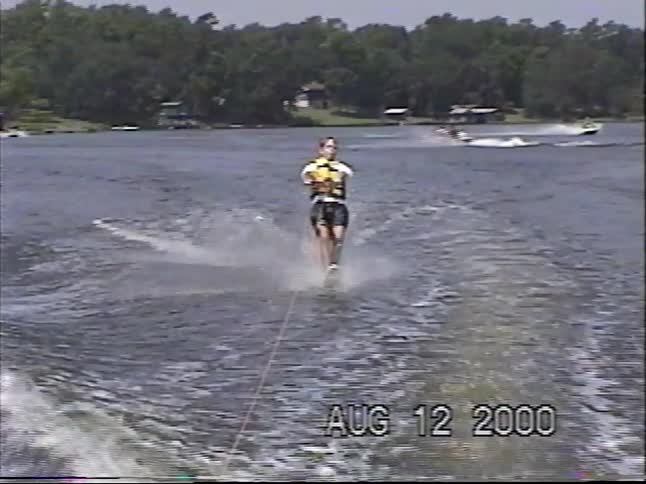 A vintage home video from 2000 captures a young man enjoying a day of slalom water skiing on a lake
