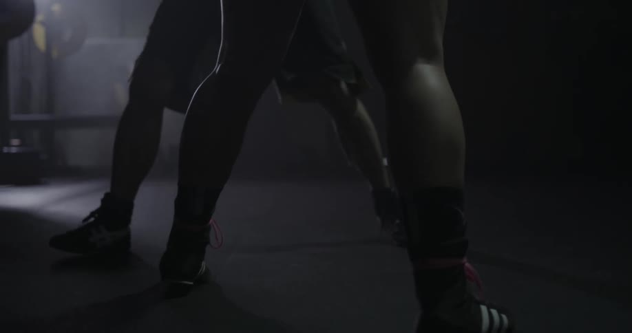 Two people box together in a room