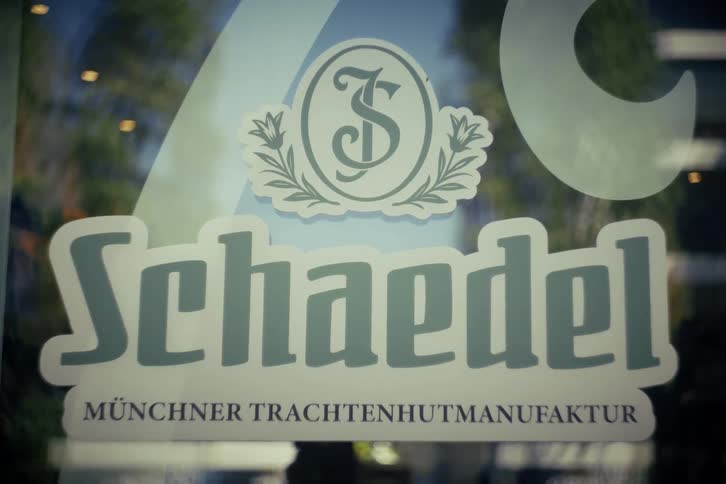 A close-up on the logo of a traditional German hat maker on a storefront window