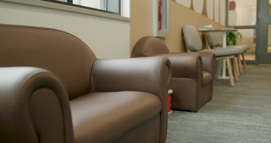 Empty brown leather child-sized chairs sit in a quiet waiting room