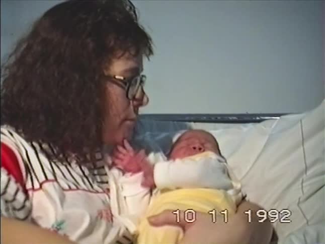 Vintage 1992 VHS footage of a new mother lovingly feeding and holding her newborn baby
