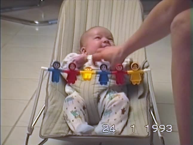 A vintage home video from 1993 shows a cute baby in a bouncer laughing hysterically while being tickled
