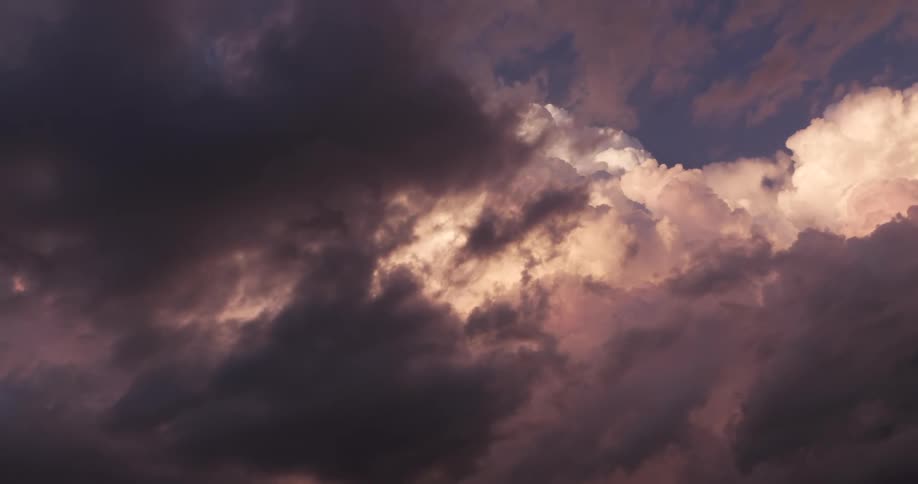 Dramatic purple and black storm clouds gather in the sky, illuminated by a warm, painterly sunset glow