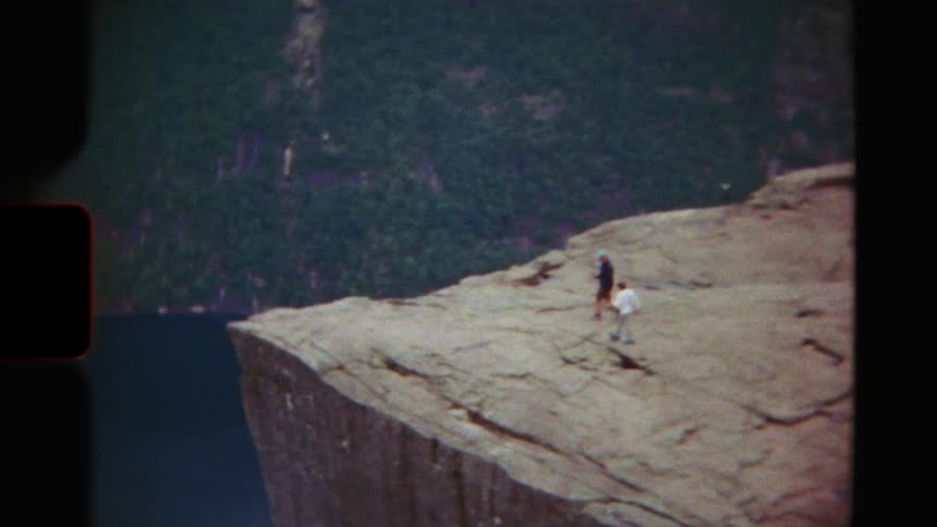 Vintage 8mm footage reveals hikers standing atop the famous Preikestolen, or Pulpit Rock, overlooking the vast and stunning Norwegian fjords