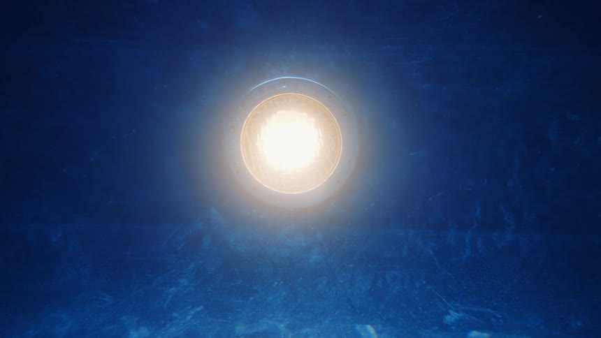 Underwater view of a glowing pool light illuminating the rippling blue water