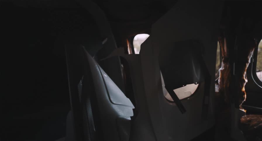A haunting view from inside a dark and destroyed airplane wreckage with broken seats