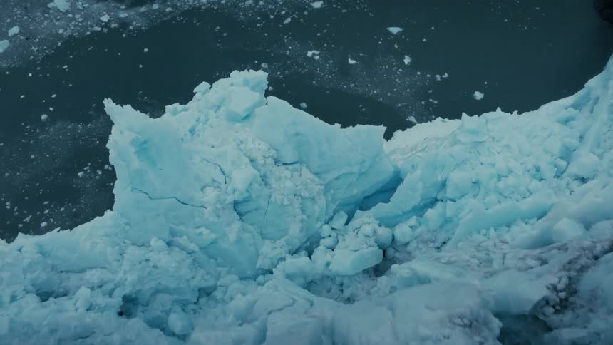 Stunning aerial perspective of a massive glacier calving into the frigid arctic ocean
