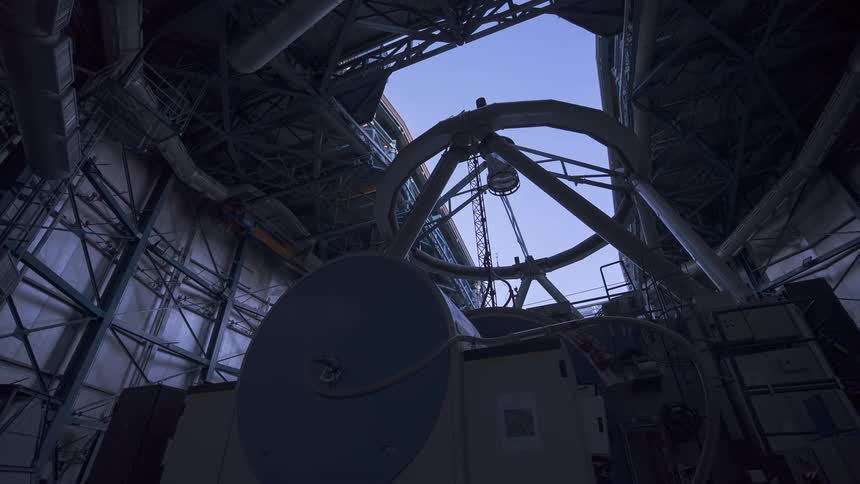 A day-to-night timelapse shows a massive telescope in an observatory as the dome opens to reveal the Milky Way