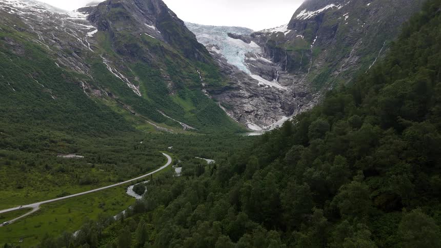A majestic aerial view reveals the stunning Boyabreen glacier nestled in a lush green valley in Norway