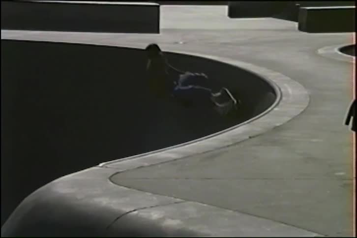Vintage VHS-style footage shows a man skateboarding in a concrete bowl at Venice Beach, performing tricks and eventually wiping out