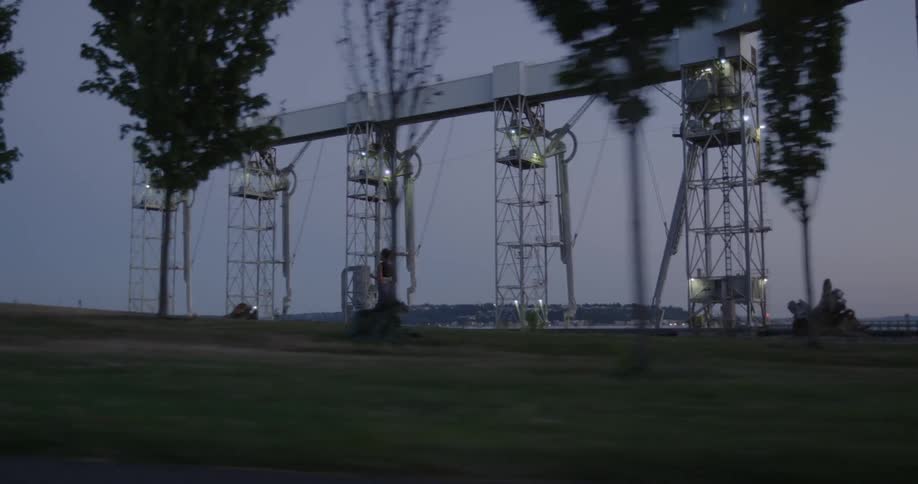 A woman jogs on a park trail near power lines