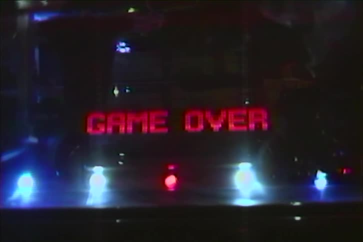 Retro VHS footage shows the digital display of a pinball machine flashing 'Game Over' and the final score