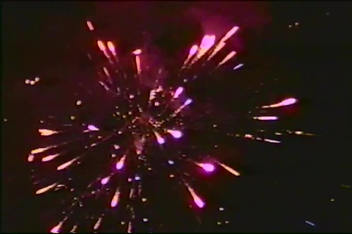 A vintage VHS recording captures a colorful fireworks display exploding against the dark night sky