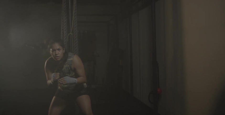 Woman shadowboxing and training while bobbing back and forth beneath a rope