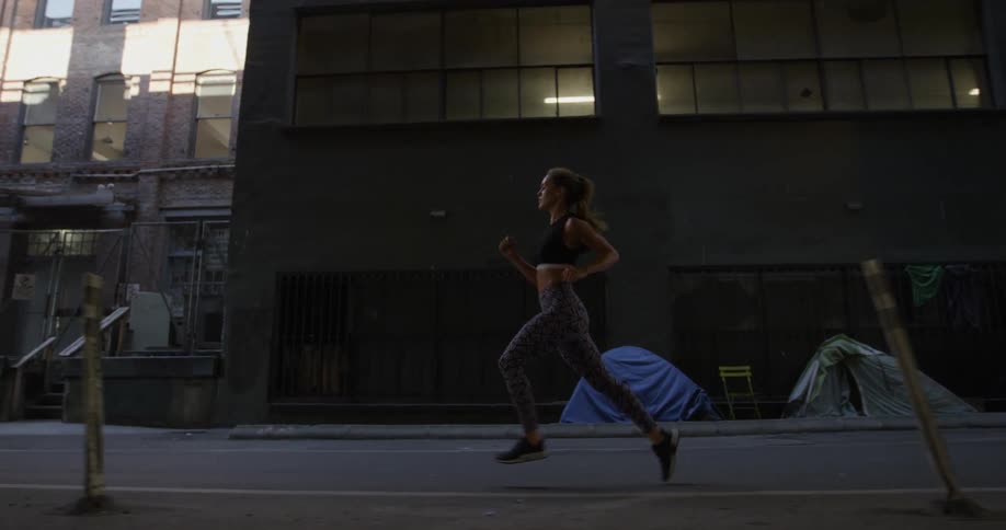 A woman is running in the city on a sunny day