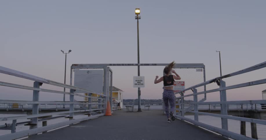 A woman is running down the pier