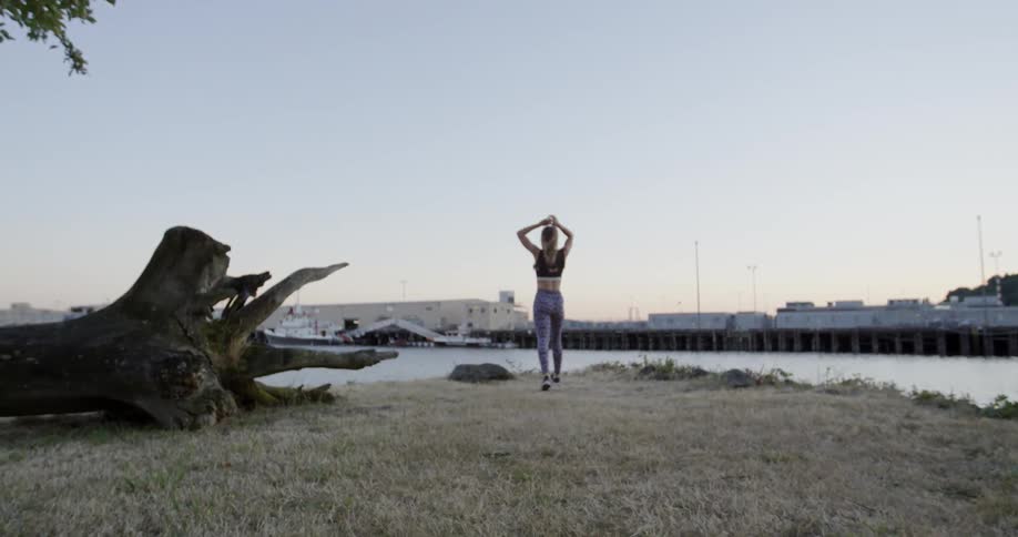 A woman jogs toward a body of water