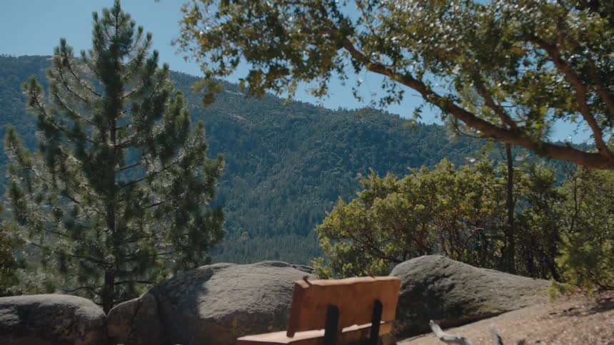 Dizzying vertigo effect shot of a serene mountain overlook with a wooden bench