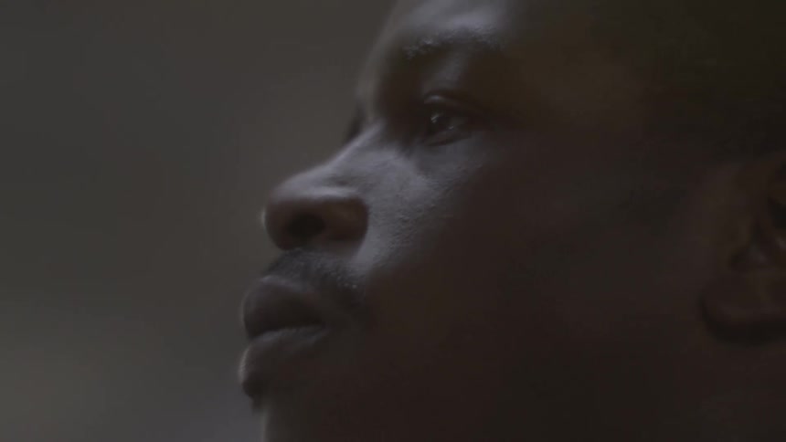 A dramatic close-up of a man's face in profile, looking up with a focused and contemplative expression