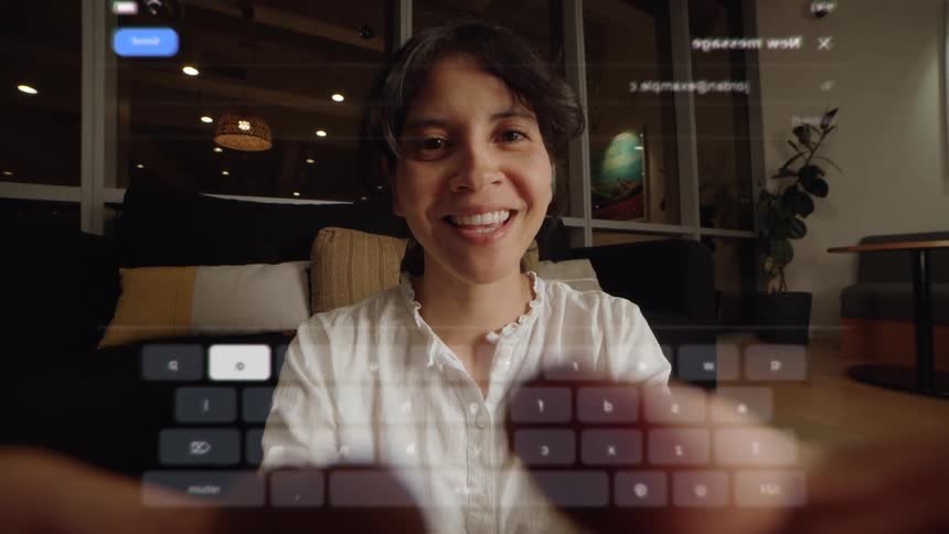 First-person view of a smiling woman typing on a holographic augmented reality keyboard in her modern living room at night