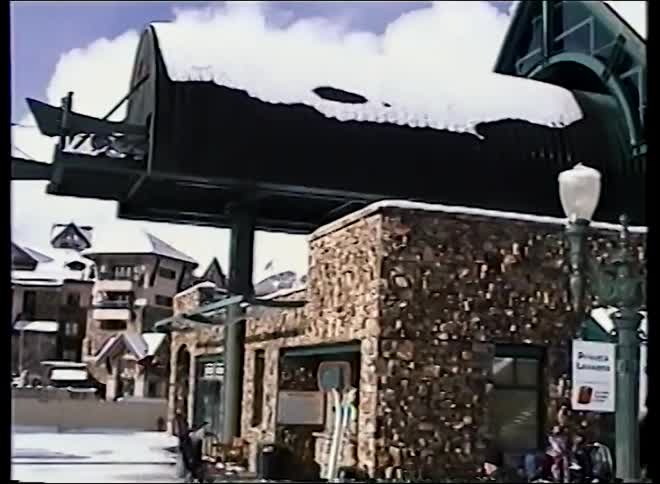 Vintage 90s footage pans across a bustling Telluride ski resort on a sunny day, showing skiers, lodges, and lifts