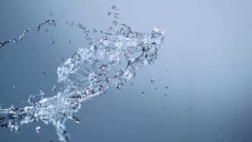A beautiful splash of clear water creates intricate patterns as it moves in super slow motion against a clean studio background