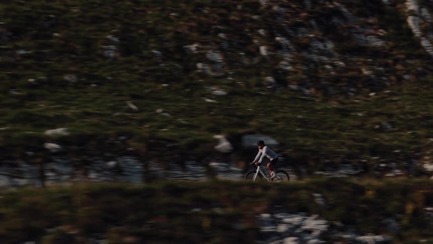 A determined cyclist pedals up a steep mountain road during a challenging training ride