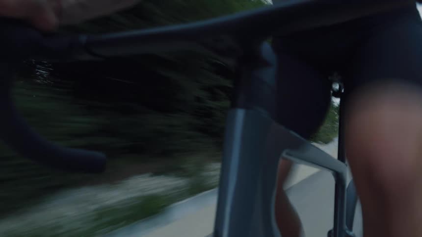 Close-up action shot of a cyclist's strong legs pedaling a modern road bike at high speed
