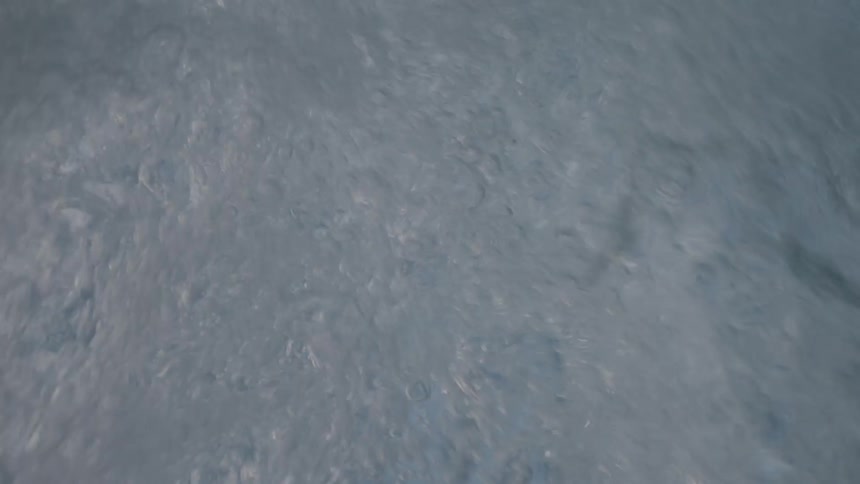 An immersive underwater point-of-view shot captures the chaotic churning of turbulent water and rising bubbles