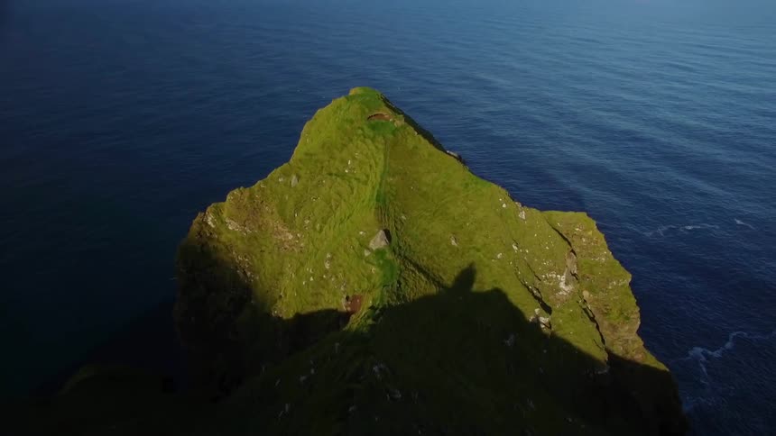 A building is perched on an island cliff