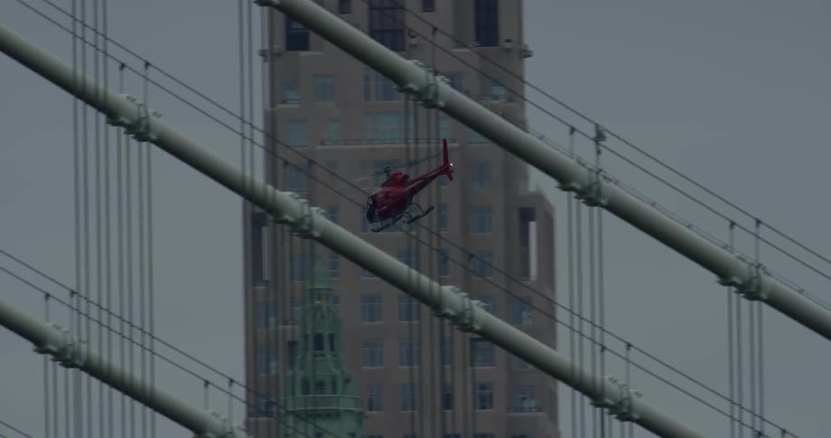 A helicopter flies past city buildings