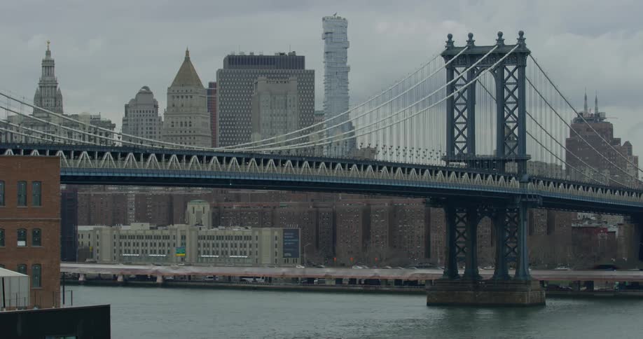 Cars drive over a bridge towards a city