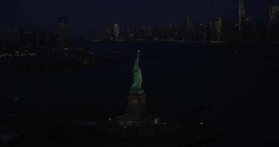 The statue of liberty stands tall at night