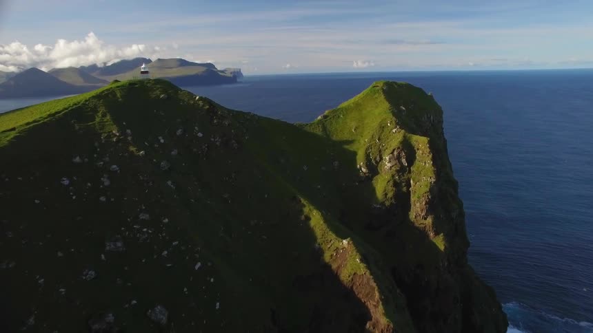 Lighthouse on top of a cliff near water