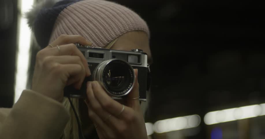 A woman is taking a picture with an SLR-type camera