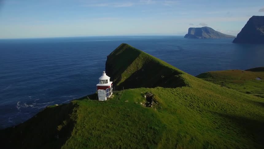 A white tower is on this green hill