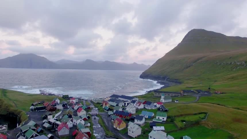 A creek runs through a quaint village towards the ocean
