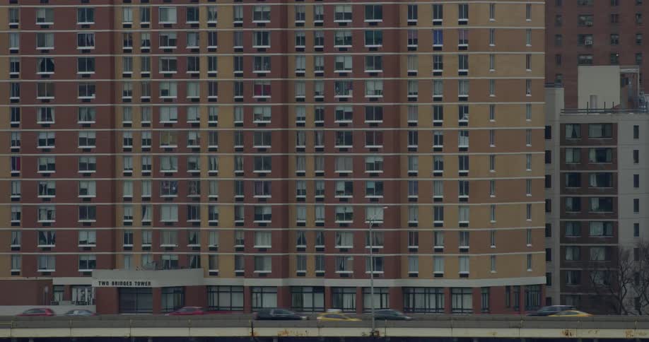 Traffic moving before a large high-rise building